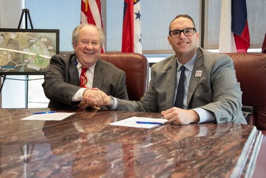 Photo: Wadley Regional Medical Center President Tom Gilbert and A&M-Texarkana President Dr. Ross Alexander shake hands after signing the new educational partnership between the medical center and the university.