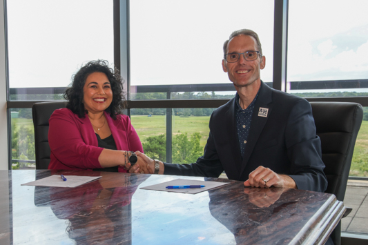 Kristina Rivas, Co-Founder and Executive Director of Ground Floor Collective and TAMUT President Dr. Ross Alexander sign a memorandum of understanding between the non-profit and the university. The new partnership allows full-time employees of Ground Floor Collective to take discounted courses at the university.