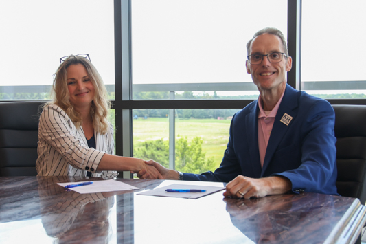 Morgan Raffray, Human Resources Manager for Transco and Dr. Ross Alexander, President of A&M-Texarkana sign an agreement establishing a partnership between the university and the railcar service company.