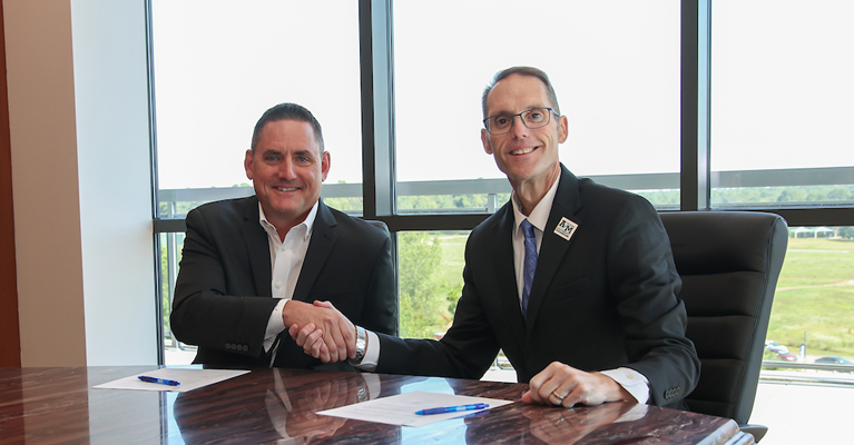 Mike Smith, CEO of Complete Computing Solutions and Dr. Ross Alexander, Texas A&M University-Texarkana President, sign a partnership agreement between the technology services company and the university. The partnership allows Complete Computing Solutions employees to receive discounted tuition on coursework at A&M-Texarkana.