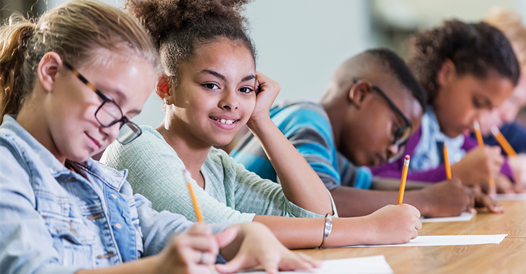 Children writing and smiling